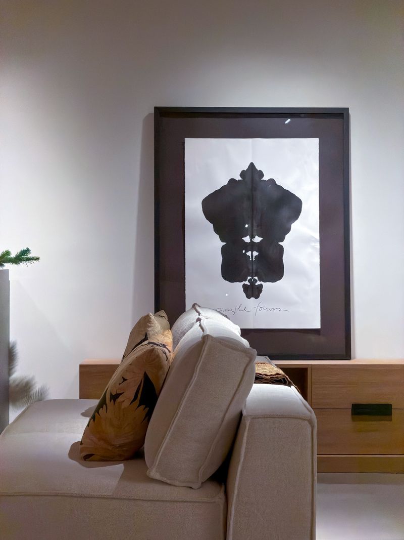 Großes schwarz-weißes Kunstwerk über einem hellen Sofa