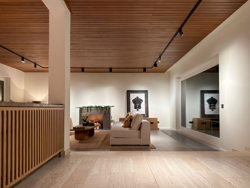 Wohnraum unter einer Holzlamellendecke, Sofa vor gerahmter Kunst
